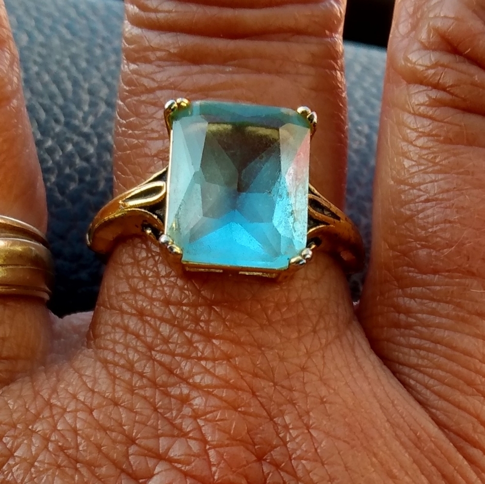 Aquamarine faceted stone in gold setting ring